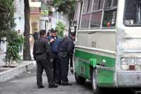 Policías bancarios revisan el microbús con el cual delincuentes intentaron cerrar el paso a una camioneta de traslado de valores para asaltarla, ayer entre las calles Lago Zirahuén y Laguna de Tamiahua