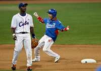 Lee Yong-kyu de Corea del Sur festeja un hit de su equipo en la séptima entrada durante el encuentro contra la escuadra cubana ante la desazón del shortstop Eduardo Paret