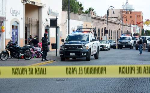 Policías de Guadalupe, Zacatecas, y agentes ministeriales custodian el sitio donde fueron asesinadas dos personas que esperaban ingresar a un banco en la calle Heroico Colegio Militar.