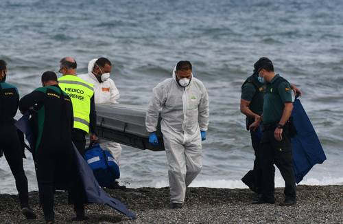 El cuerpo de un migrante es retirado por forenses en la playa de Ceuta.