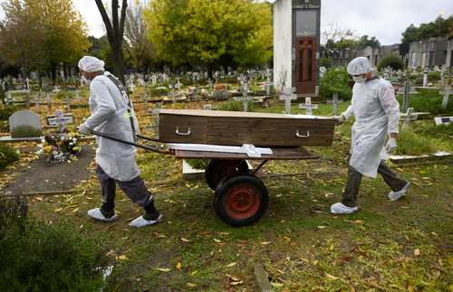 Trabajadores de un panteón trasladan los restos de una víctima de Covid-19 en Buenos Aires, Argentina, país que impuso desde ayer su primer bloqueo estricto del año ante el alza de contagios y muertes.