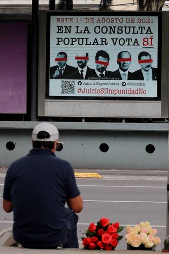 Un vendedor ofrecía, la semana pasada, flores a los automovilistas que circulan por el Eje 4 y Circuito Interior, frente a un promocional de la consulta ciudadana que se desarrollará el próximo domingo.