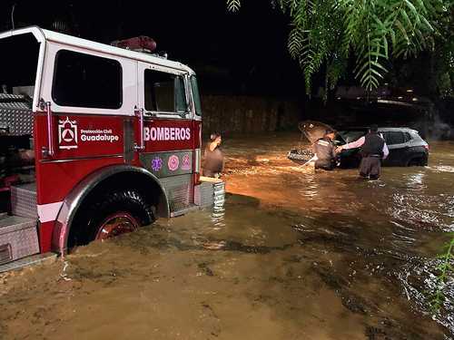 Bomberos y policías municipales de Guadalupe, Zacatecas, auxiliaron a un conductor luego de que su vehículo quedó atrapado en una avenida inundada del fraccionamiento Villas de Guadalupe, debido a la intensa lluvia la noche del martes.
