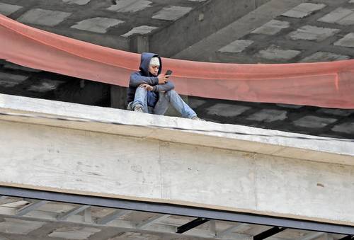 Un trabajador de la construcción aprovecha la hora de comida para revisar su teléfono celular, en un edificio en construcción de la avenida Insurgentes Sur.