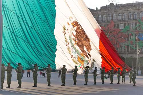 Integrantes de la Policía Militar de la Sedena, durante la ceremonia de izamiento de la bandera en el Zócalo capitalino,este domingo por la tarde.