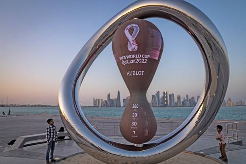 En Doha, niños observan el reloj que lleva la cuenta oficial para el inicio de la copa.