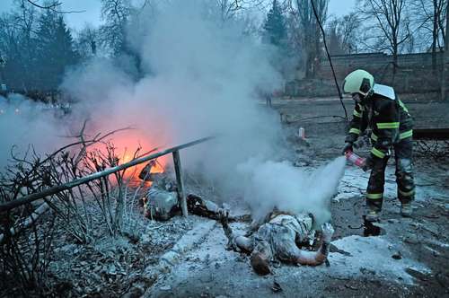 Un bombero extingue los cuerpos de transeúntes muertos durante un ataque aéreo que destruyó la principal torre de televisión de Kiev.