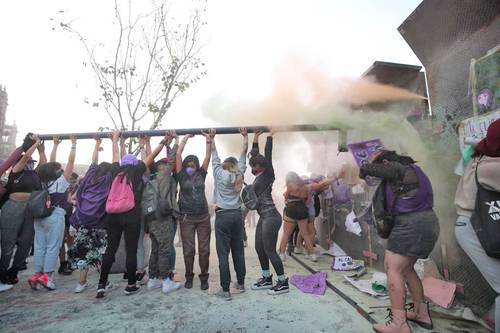 UNIDAS CONTRA LAS VALLAS. Marchistas golpean la estructura metálica que protege Palacio Nacional, en el contexto de la protesta por el Día Internacional de la Mujer.
