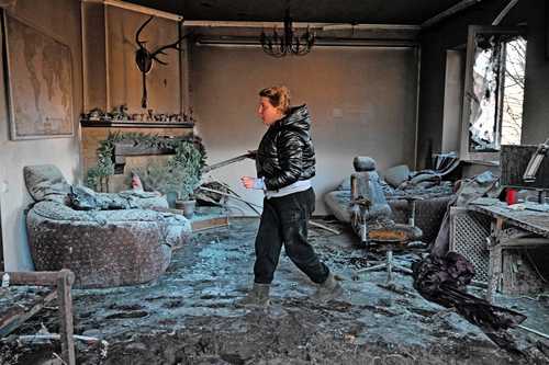 Una mujer inspecciona los escombros de una casa en el distrito de Osokorky, en el sureste de Kiev. Poderosas explosiones sacudieron los distritos residenciales de Kiev este martes y mataron a dos personas.