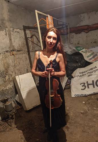 La intérprete Vera Lytovchenko posa con su violín en el sótano de un edificio en Járkov, Ucrania.