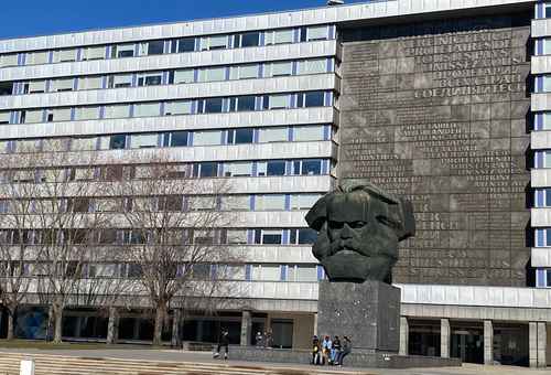 Busto de Karl Marx en Chemnitz. Al fondo, la placa de bronce con la inscripción en varios idiomas “Proletarios del mundo, uníos”.