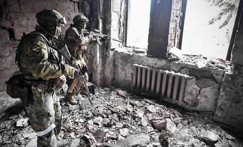 Soldados rusos vigilan desde un teatro que fue bombardeado el 16 de marzo en Mariupol, al intensificar ayer el asedio al estratégico puerto en el este de Ucrania.