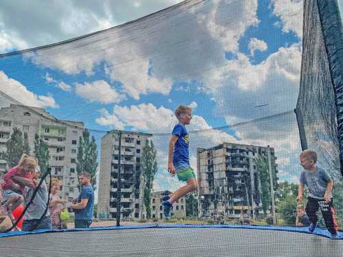 En medio de la devastación en la ciudad de Borodianka, zona noroeste de Kiev, los niños se divierten en un parque.