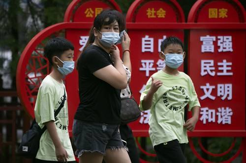 Cada día se ve a máspersonas con cubrebocas en las calles y parques públicosde Pekín.
