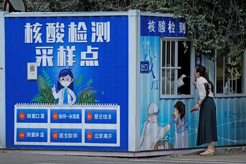 Una mujer se realiza una prueba rápida para detectar el virus SARS-CoV-2 en un kiosco que muestra las regulaciones en Pekín.