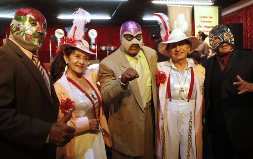 Los luchadores Canek, El Fantasma y Máscara Año 2000, acompañados por pachucos en la conferencia realizada en el Salón Los Ángeles para dar a conocer la oferta cultural de la Ciudad de México en el 50 FIC.