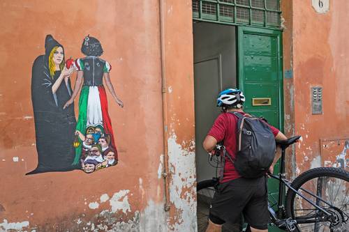 Un artista callejero retrató a la líder ultraderechista, Giorgia Meloni, como la bruja que ofrece a Italia (Blanca Nieves) una manzana envenenada, mientras políticos se esconden bajo su falda.