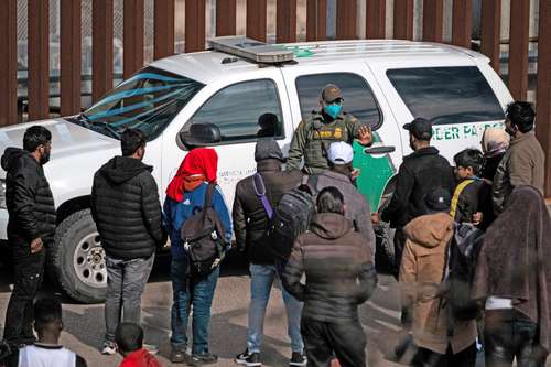 En la imagen, un guardia de la Patrulla Fronteriza se dirige a un grupo de indocumentados que cruzaron a Estados Unidos desde Tijuana antes de ser procesados.