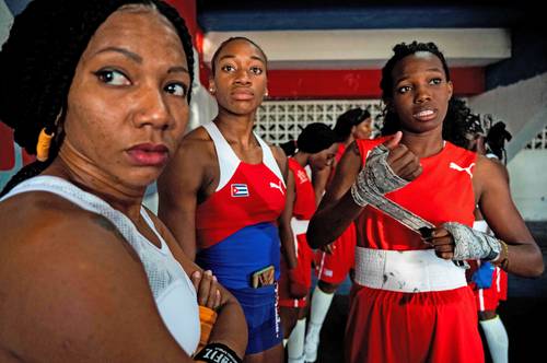 Namibia Flores (izquierda), pionera del boxeo en la isla, asesora a las pugilistas como Elianni García (derecha), quien ganó el primer combate oficial.