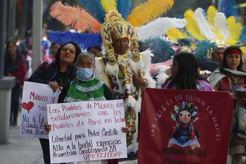 Indígenas portan pancartas a favor de la libertad del depuesto Pedro Castillo durante su marcha ayer por la avenida Reforma, en la CDMX, para participar en la tercera Feria de la Muñeca Lele, que tiene lugar en el Monumento a la Revolución.