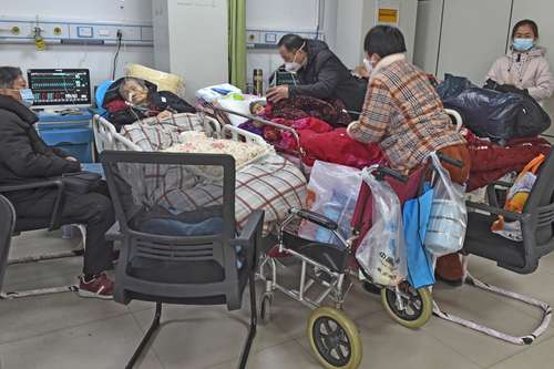Familiares cuidan a sus parientes con SARS-CoV-2 en sala de emergencias, en la provincia china de Anhui.