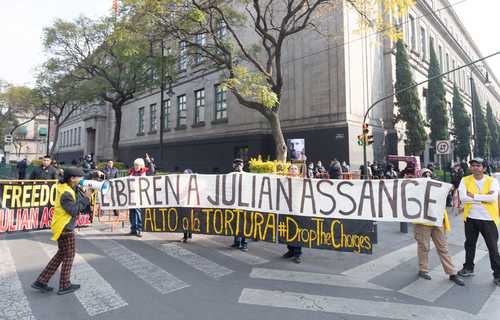 Activistas se manifiestan en el trayecto del presidente de Estados Unidos hacia Palacio Nacional, en apoyo al fundador de WikiLeaks.