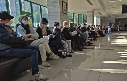Familiares de fallecidos permanecen en la sala de espera de un crematorio en Shanghái, en China.