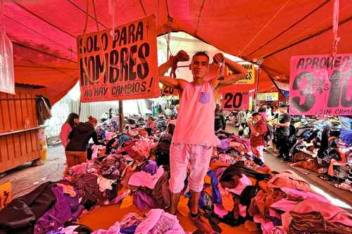 Un vendedor de ropa usada en un tianguis en inmediaciones del Metro Tepalcates, en la calle Francisco Leyva, colonia Juan Escutia, alcaldía Iztapalapa.