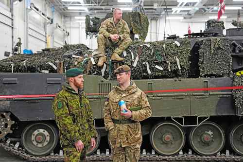 En Estonia, antes de la reunión del Grupo de Contacto en la ciudad alemana de Ramstein, militares de diferentes países conversan cerca de un Leopard 2.