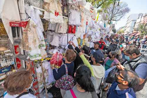 Vendedores ambulantes de la Plaza Talavera exhiben vestuario para Niños Dios.