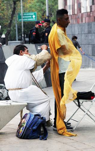 Un curandero limpia “las energías negativas” a un cliente, cerca del Metro Hidalgo, en la Ciudad de México.