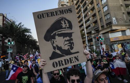 En Santiago, una muchedumbre protestó contra el asesinato del oficial Daniel Palma. En el contingente, levantaron una pancarta alusiva al dictador chileno Augusto Pinochet.