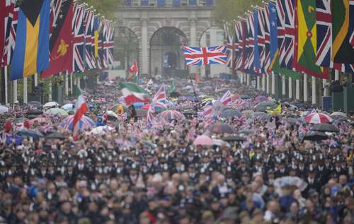 Una multitud de simpatizantes de la monarquía se dirige al palacio de Buckingham tras la ceremonia de unción del rey.
