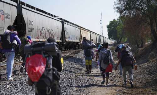 Migrantes intentan subir a un tren que pasa por Huehuetoca, estado de México.