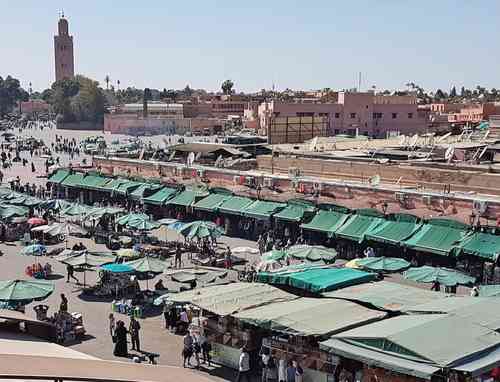 La plaza mayor, en el centro de Marrakech, Patrimonio Cultural de la Humanidad; al fondo, el minarete de la mezquita Kutubía.