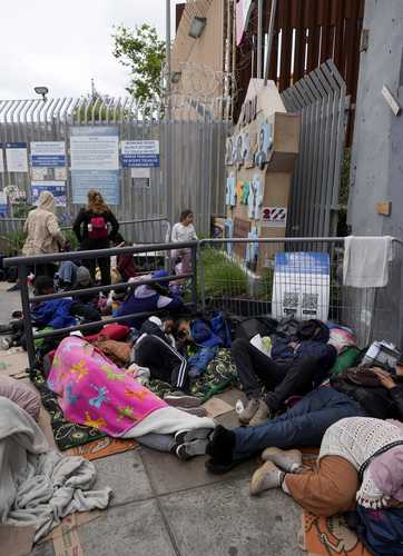 En el puente de San Isidro, migrantes esperan ser recibidos para entrar a EU.