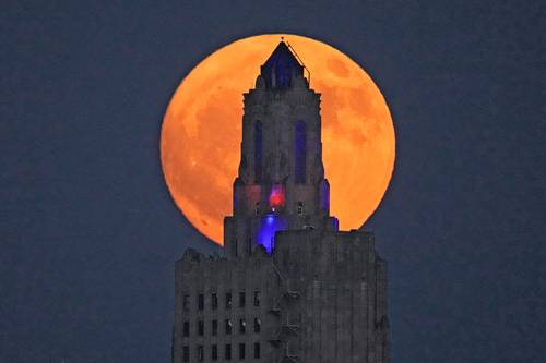 Astro giboso creciente detrás de un edificio de Kansas. Para este lunes se espera la primera de cuatro lunas llenas de 2023.