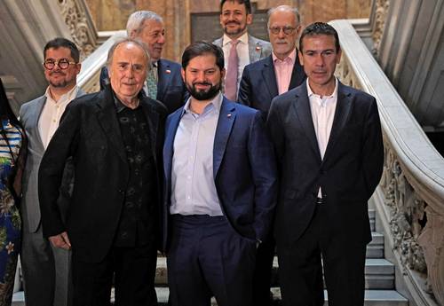 El presidente de Chile, Gabriel Boric, al llegar a Casa América en Madrid. Le acompañan el cantautor español Joan Manuel Serrat (izquierda) y Enrique Ojeda Vila (derecha), director de la sede del homenaje a Salvador Allende.