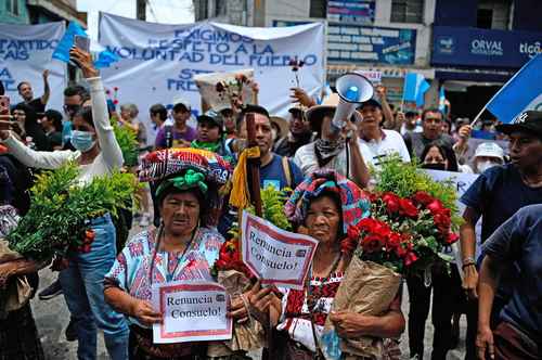 Participantes en la denominada “Marcha de las flores” corean consignas contra la fiscal general, Consuelo Porras y el juez Fredy Orellana, entre otros funcionarios, ayer, frente a la sede del Ministerio Público en la ciudad de Guatemala.