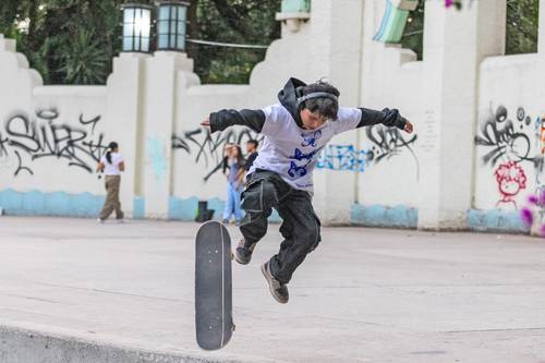 Un adolescente aprovechó el buen clima que hubo ayer para realizar acrobacias con su patineta en el parque México de la colonia Condesa.