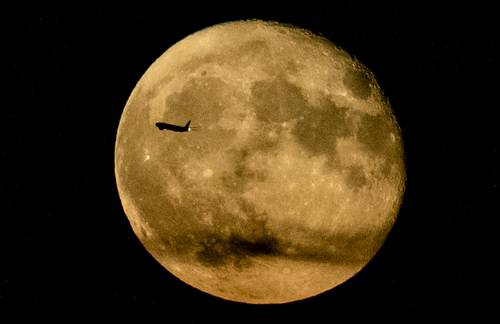 Un avión que surca el cielo desde Nueva York logra percibirse ante el resplandor lunar de ayer.
