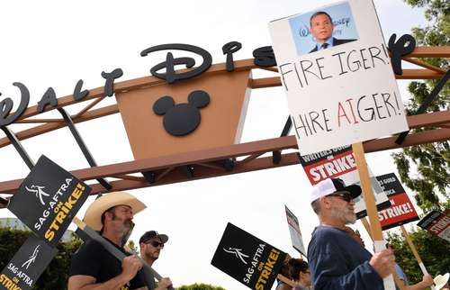 Miembros de los sindicatos de actores y guionistas protestan frente a los estudios Disney, en Burbank, California.