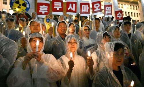Cientos de personas protestaron ayer en Seúl, bajo la lluvia, contra la decisión del gobierno de Japón de vertir al océano agua tratada de la planta nuclear de Fukushima.