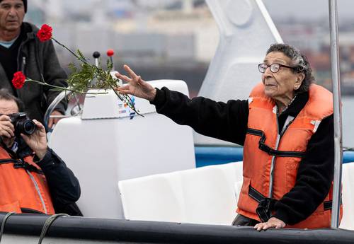 La madre de un joven de 19 años desaparecido en agosto de 1974 arroja flores al mar, en el puerto chileno de San Antonio, donde se recordó a víctimas de la dictadura.