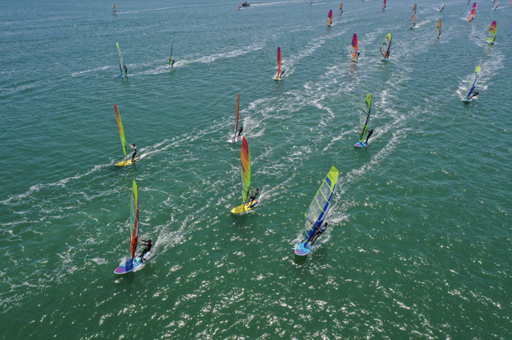Los atletas hacen windsurf en las aguas de la bahía de Sangou