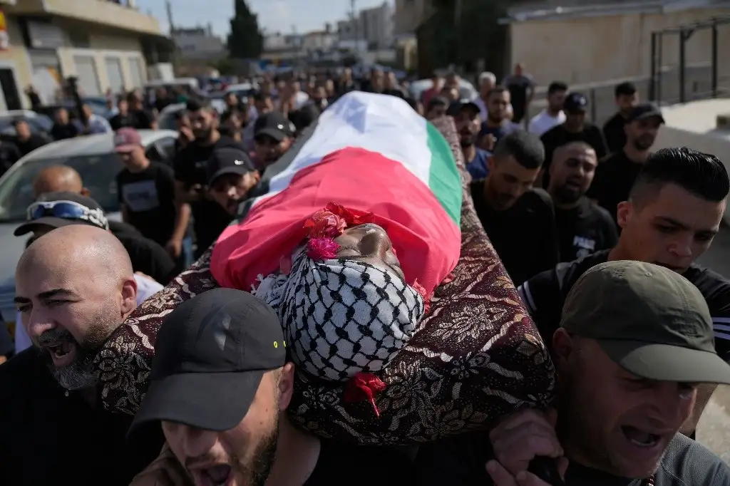 Dolientes palestinos llevan el cuerpo del niño de 12 años Mohammad Hoshiya a su sepelio, quien murió por las heridas causadas hace una semana tras un ataque del fuerzas israelíes al campo de refugiados de Al Amari. Foto: Ap